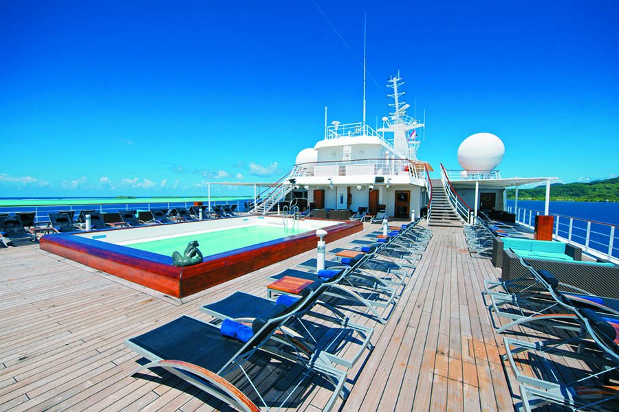 Relax on the pool deck aboard your Paul Gauguin cruise | Photo credit: Paul Gauguin Cruises