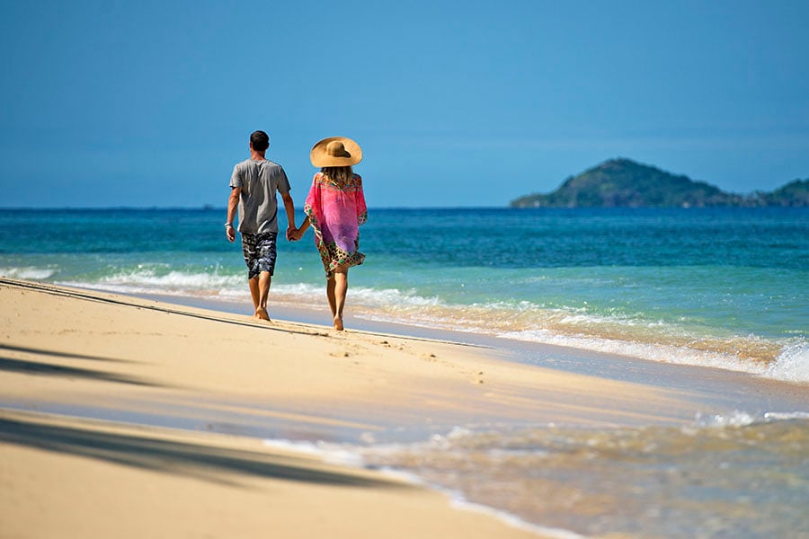 Couple walking along a deserted beach 