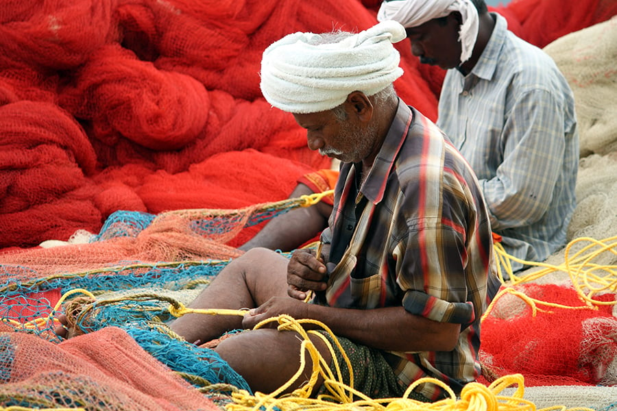 Fishermen weaving their nets, Kerala, India
