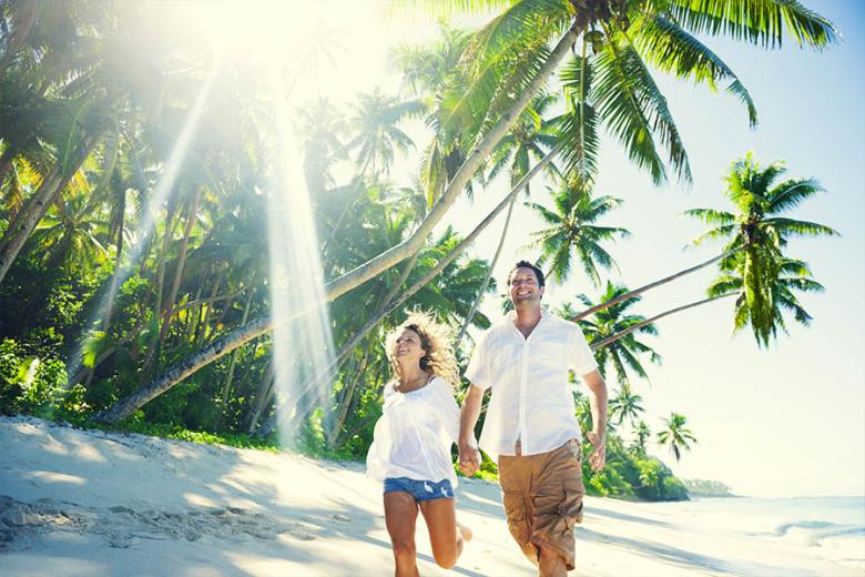 Honeymoon couple walking along the beach | Travel Nation