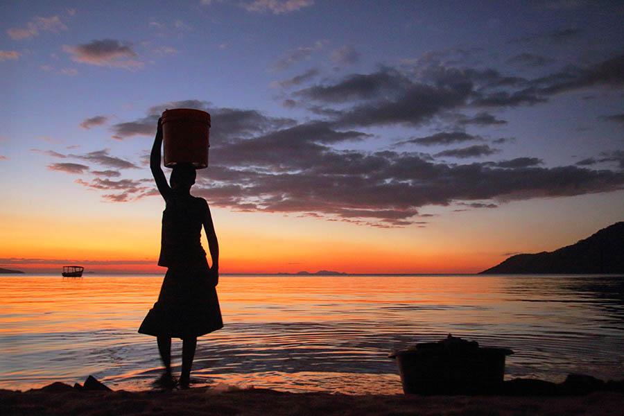 Malawi woman on a beach at sunset