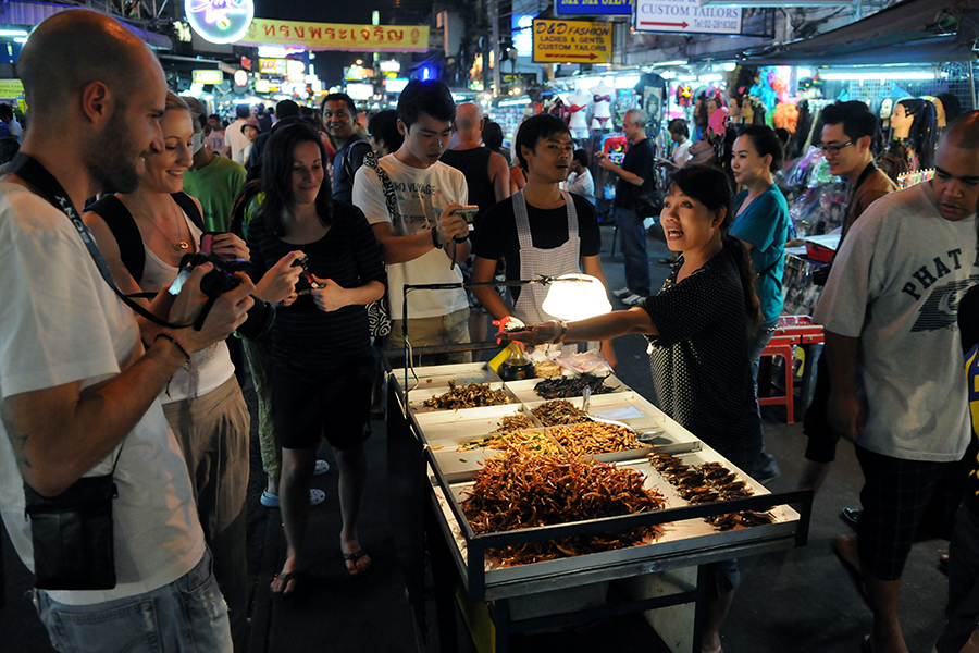 Try some delicious street food (although this lady is selling cockroaches!)